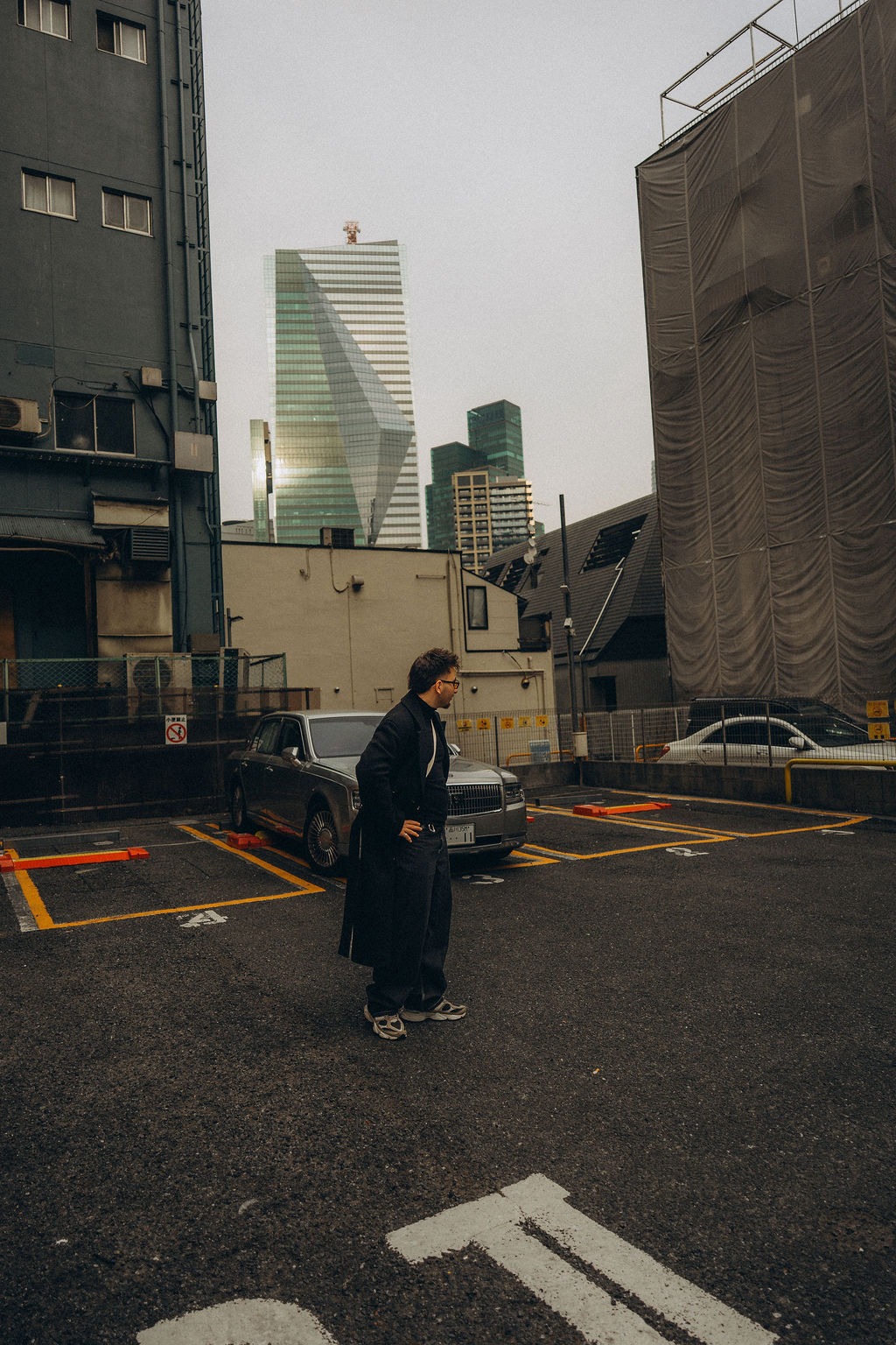 Einzelne Person auf einem Parkplatz zwischen Hochhäusern in Tokio