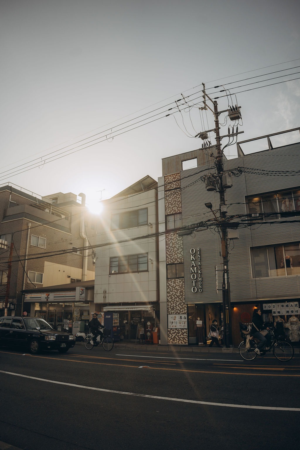 Straße mit Stromleitungen im Gegenlicht der Sonne in Kyoto