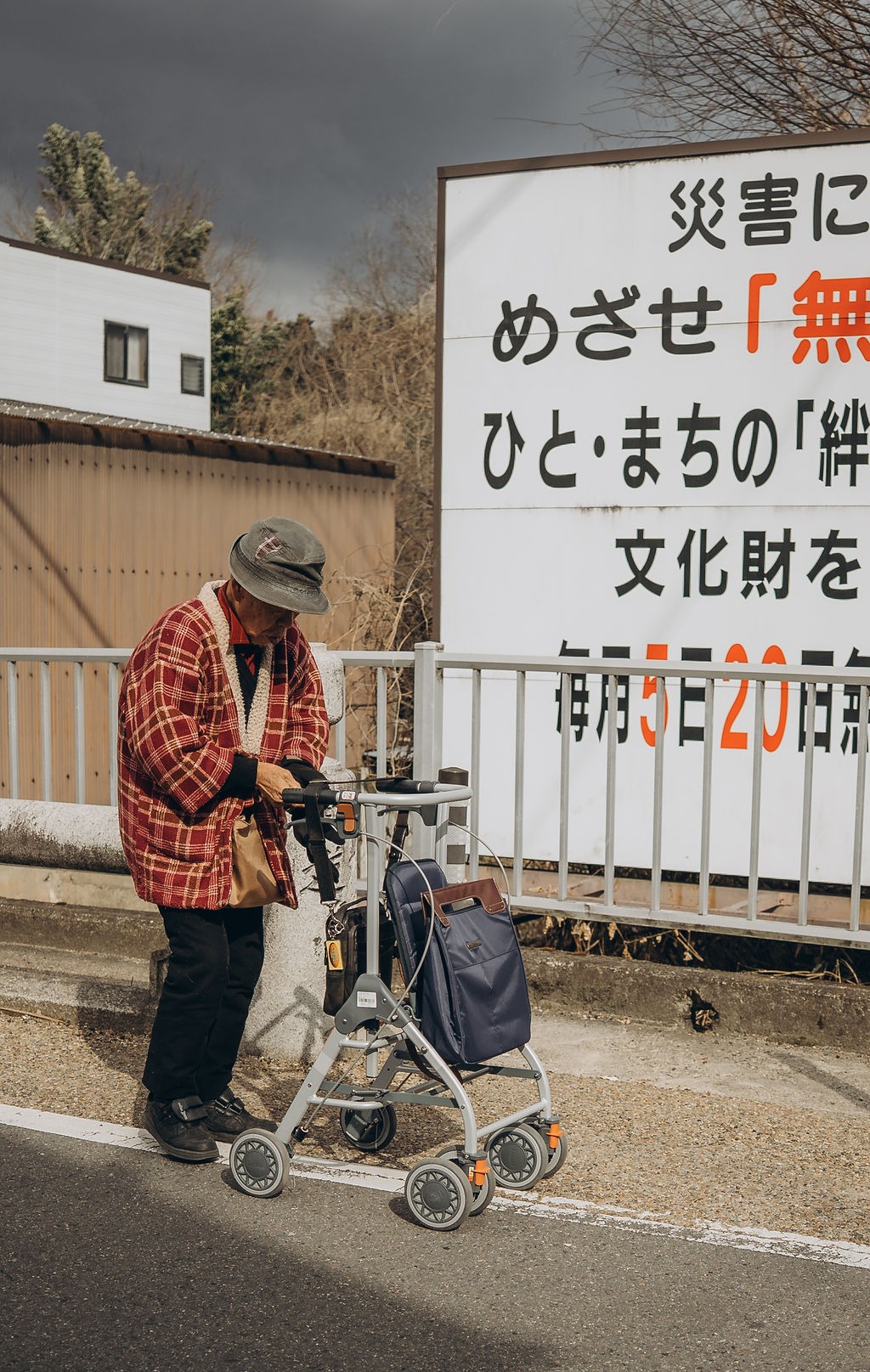Älterer Mensch mit Rollator vor einem Schild in Kyoto
