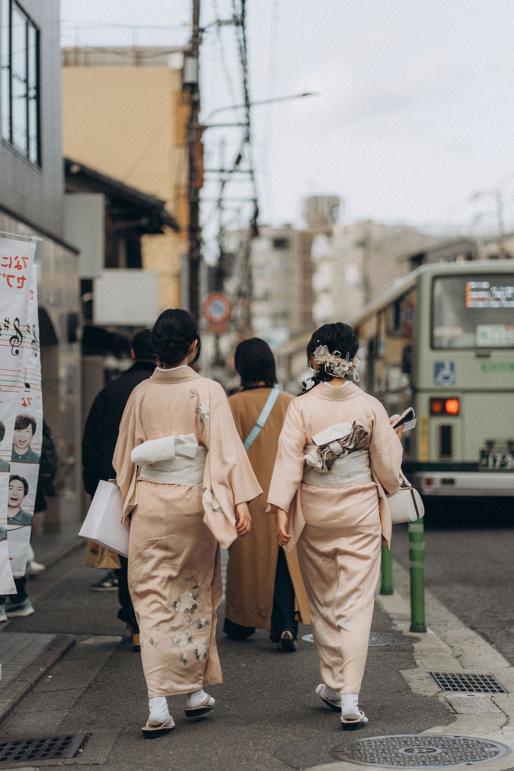 Zwei Frauen im Kimono gehen eine Straße in Kyoto entlang