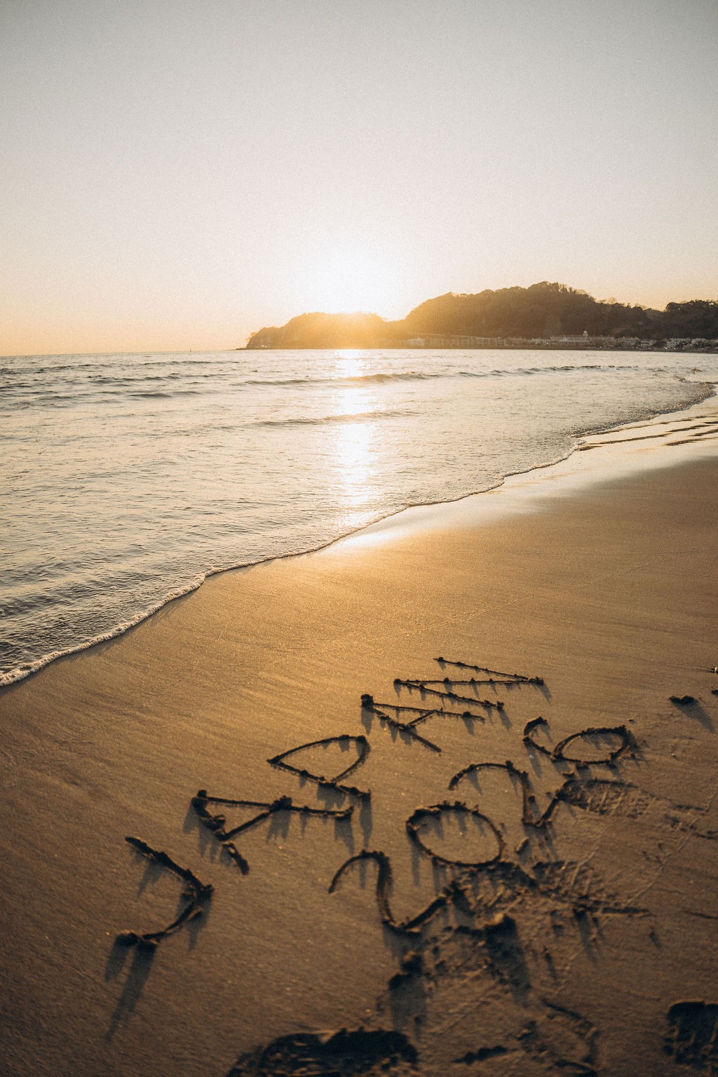 Schriftzug Japan 2026 im Sand bei Sonnenuntergang